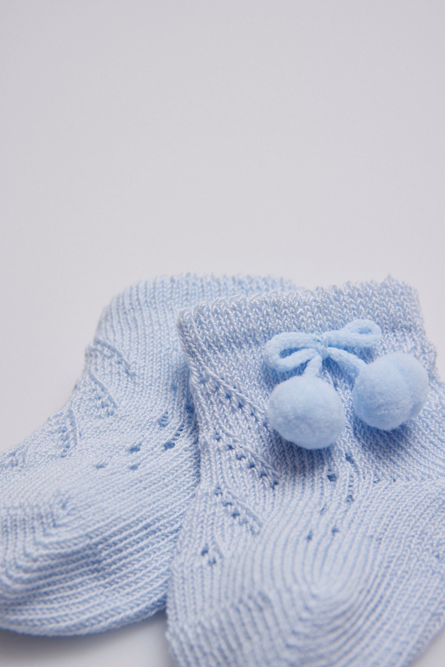 62688-1-calcetines-bebe-recien-nacido-perle-borlas-ysabel-mora-celeste