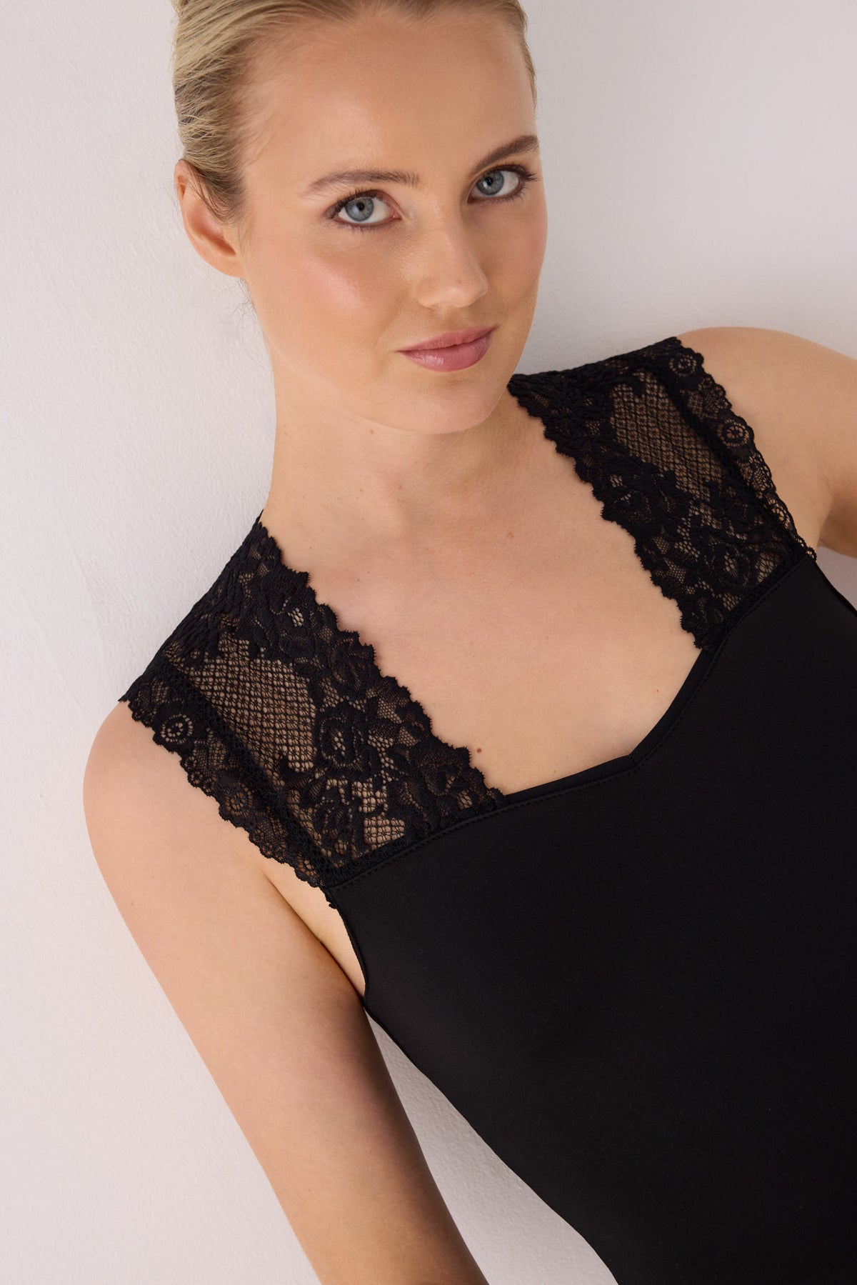 Camiseta térmica feminina sem mangas com detalhes em renda preta.