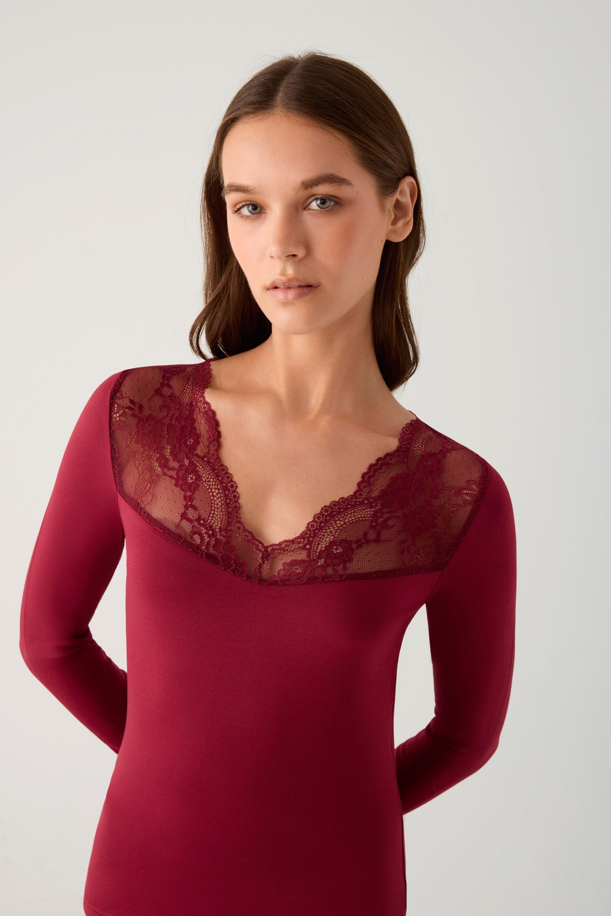 Camiseta térmica feminina de manga comprida com decote em V e detalhes em renda bordô.