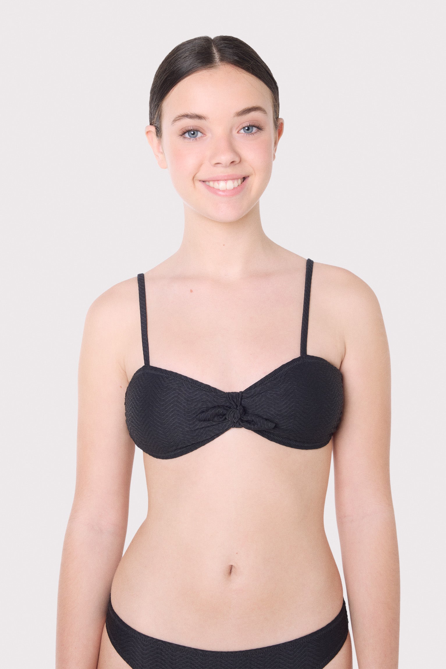 Top de biquíni juvenil texturizado com laço e bojo removível.