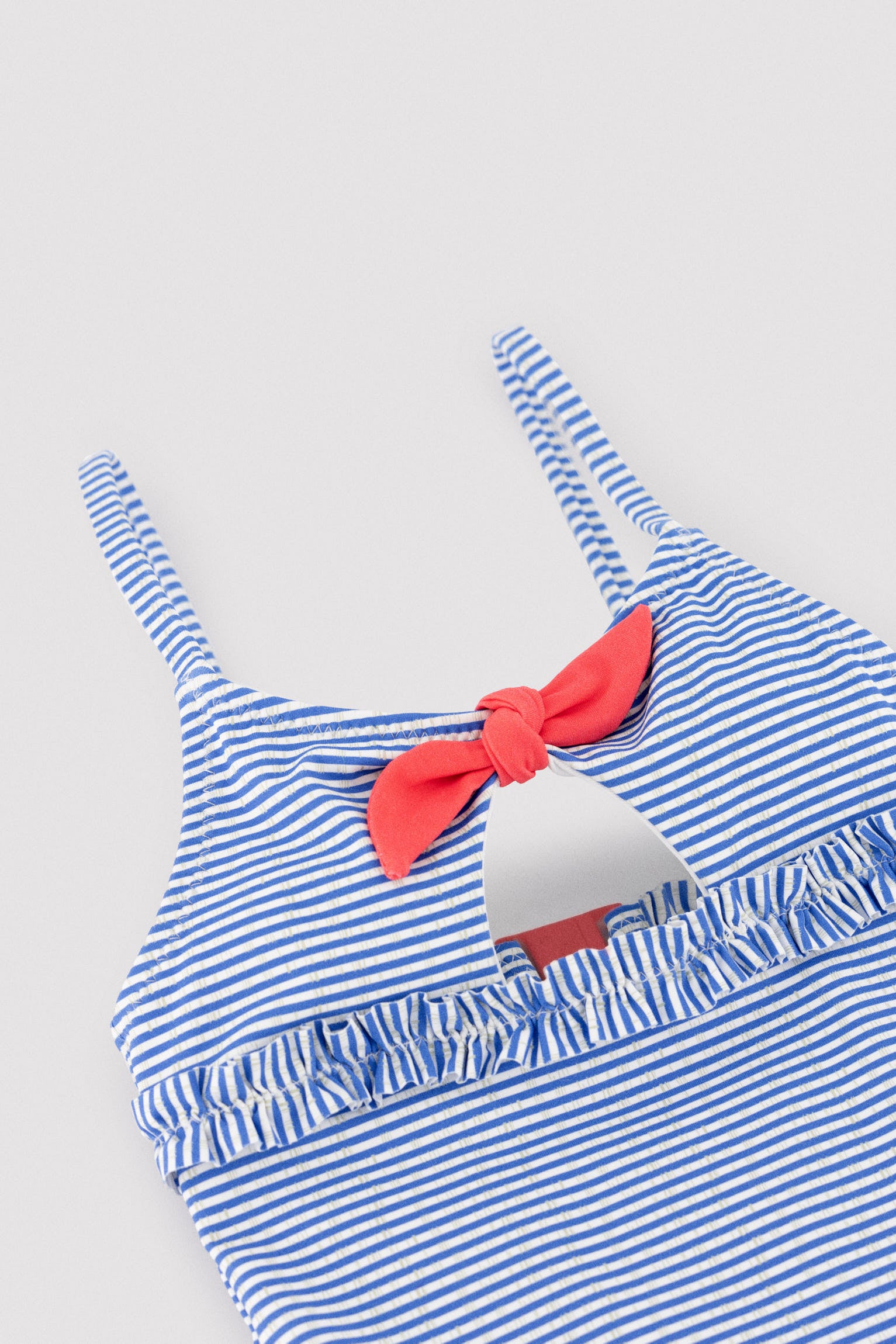 Maiô infantil com detalhe de laço e babado, estampa listrada