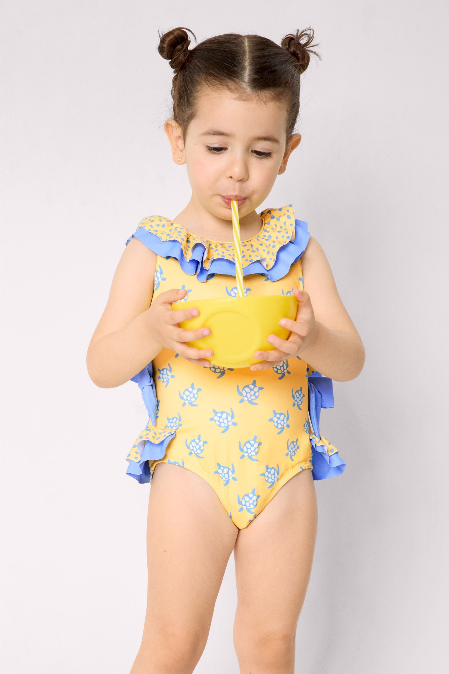 Maiô infantil com detalhes de babados e laços, estampa de tartaruga.