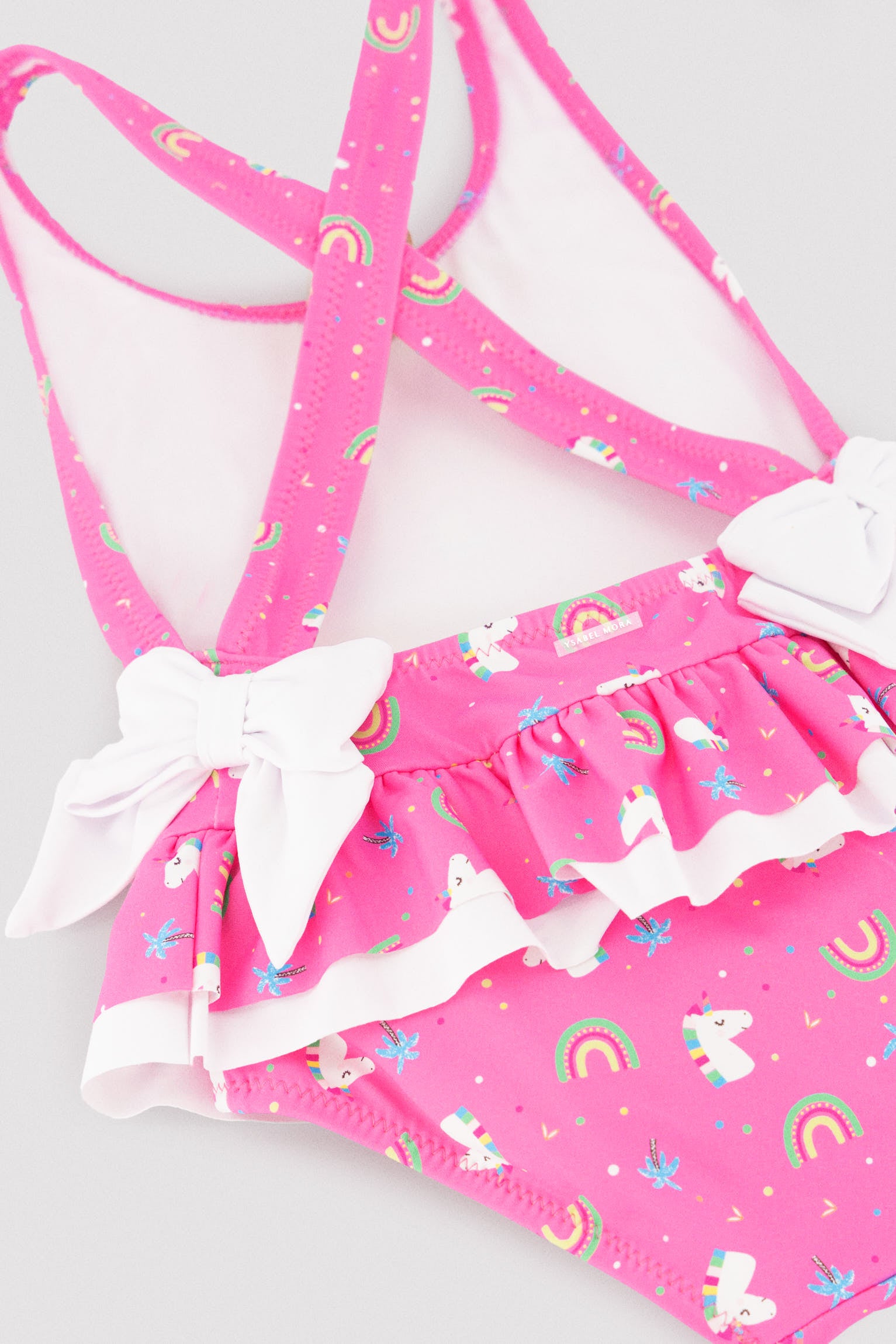 Maiô infantil com detalhes de babados e laços, estampa de unicórnio.