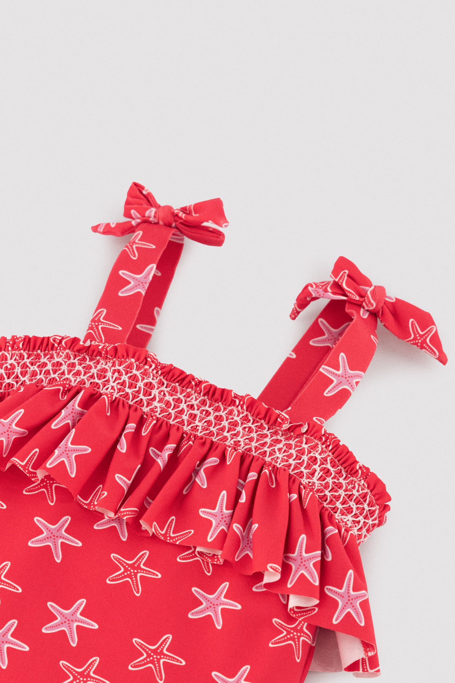 Maiô infantil com detalhe de babado e estampa de estrela-do-mar