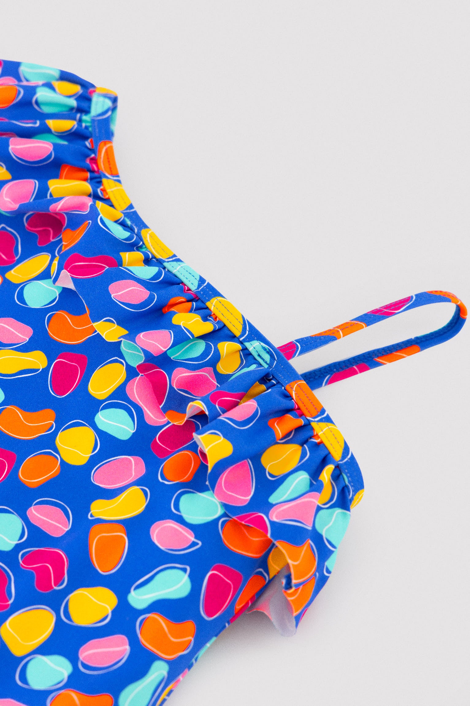 Maiô assimétrico infantil com detalhe de babado e recorte com estampa orgânica.