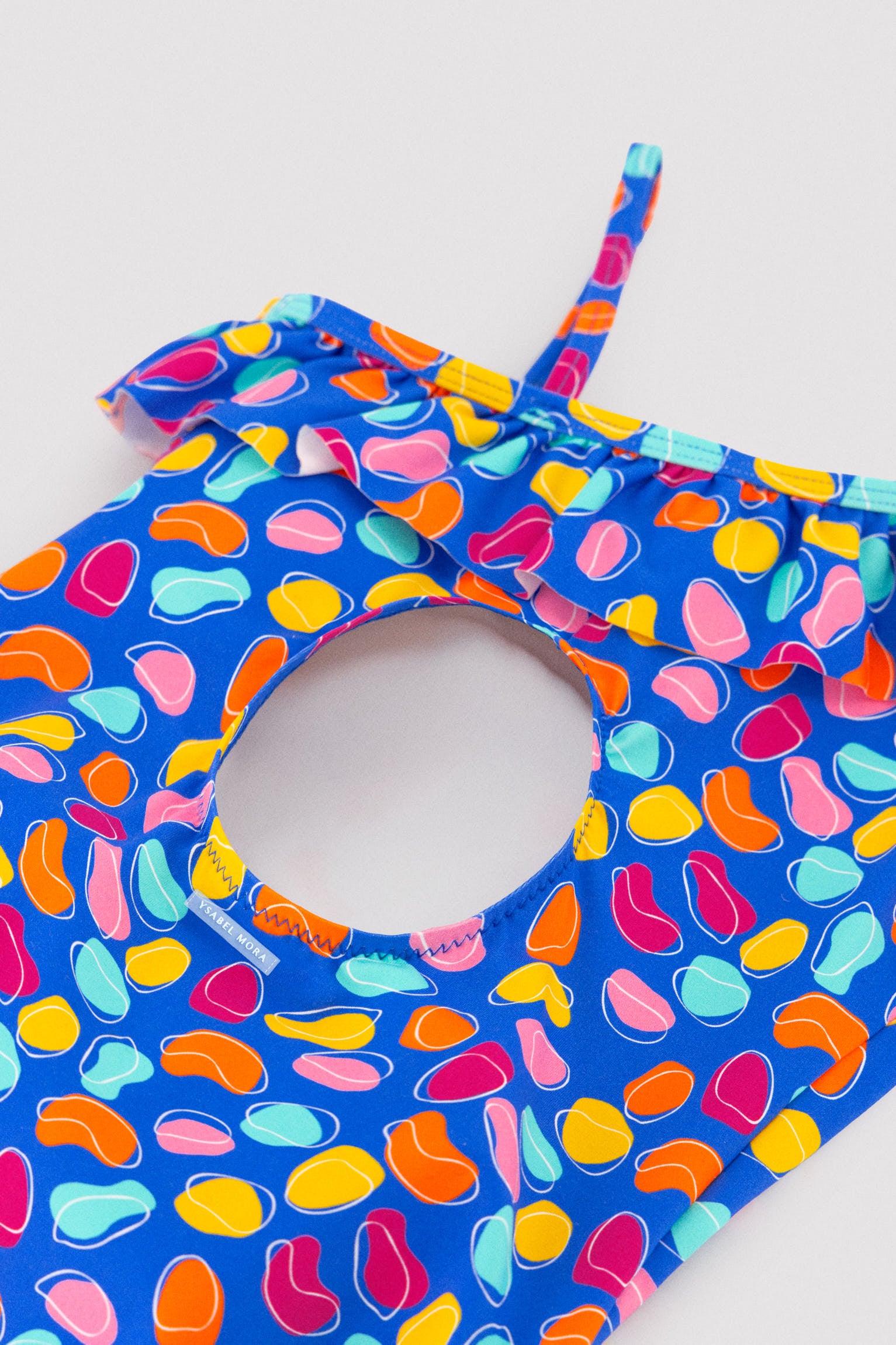 Maiô assimétrico infantil com detalhe de babado e recorte com estampa orgânica.