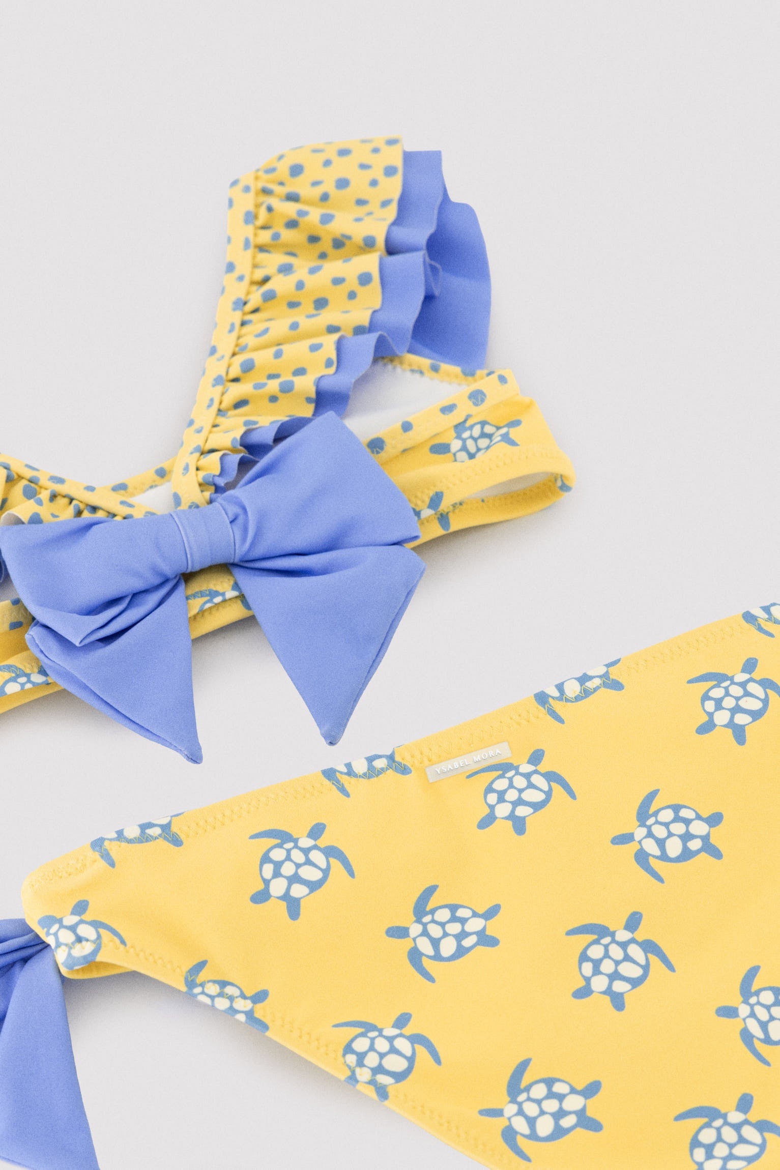 Biquíni infantil com detalhe de babados e laços, estampa de tartaruga.