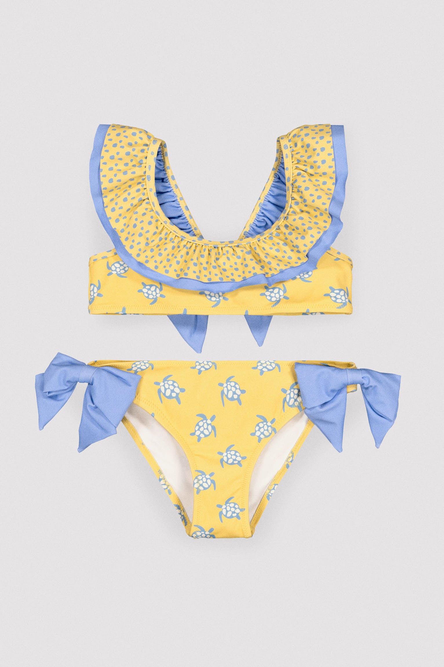 Biquíni infantil com detalhe de babados e laços, estampa de tartaruga.