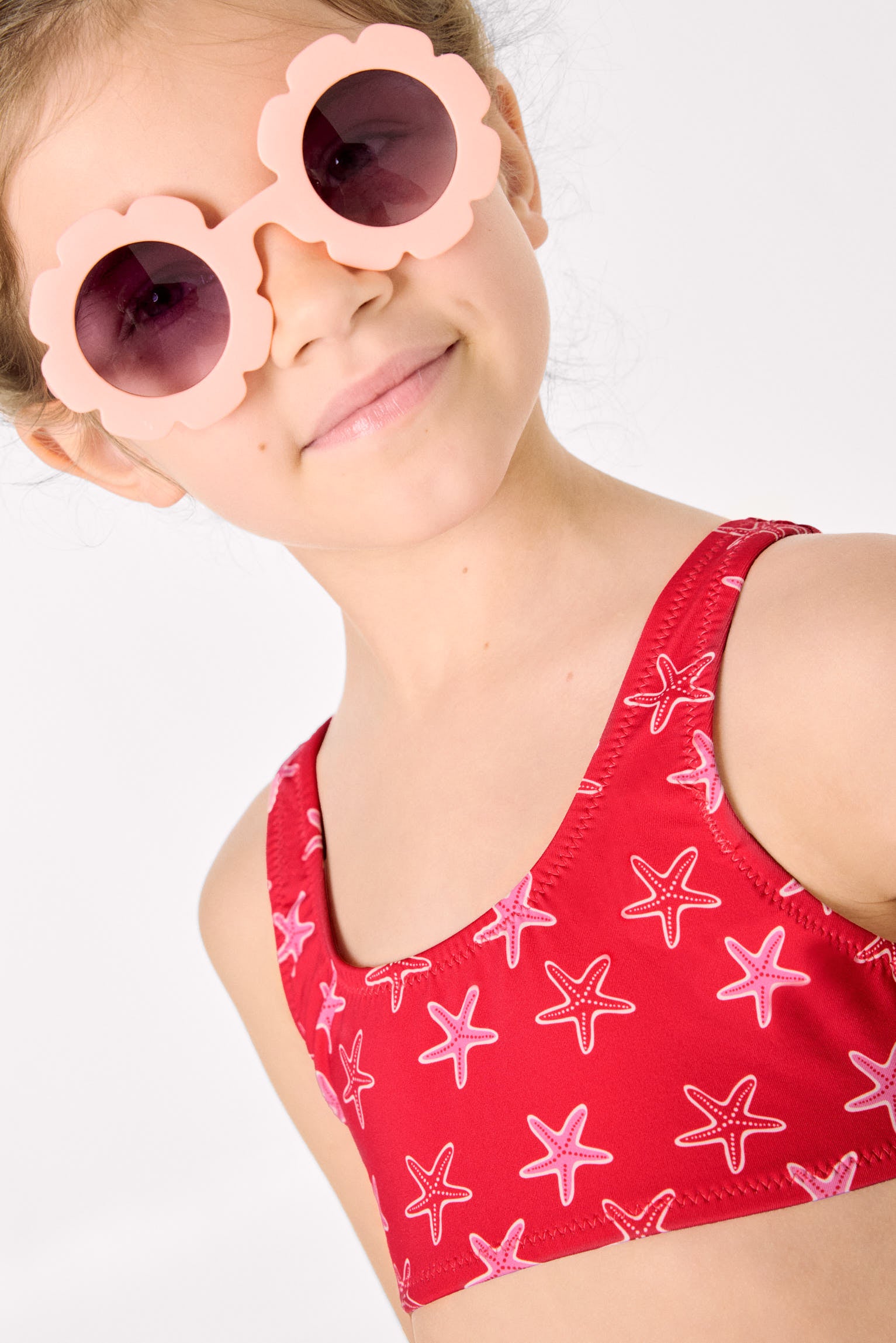 Biquíni infantil com detalhes de babados e laços, estampa de estrela-do-mar.