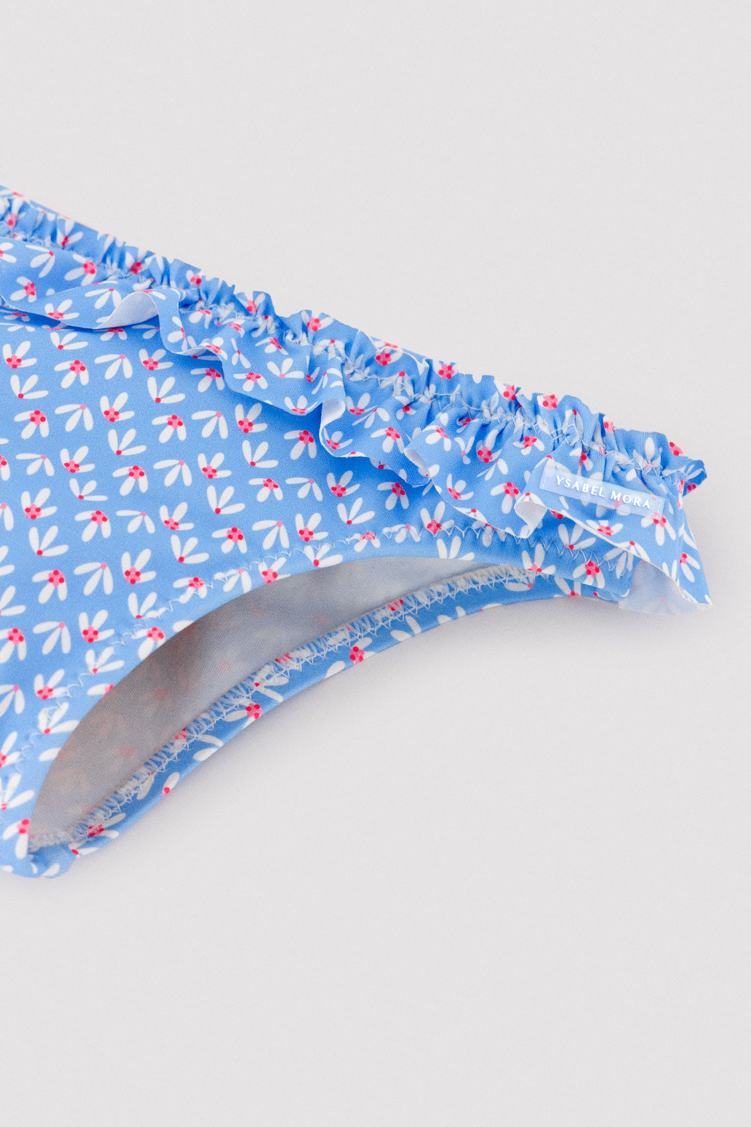 Calcinhas de bebê com detalhes de babados e laços, estampa floral.