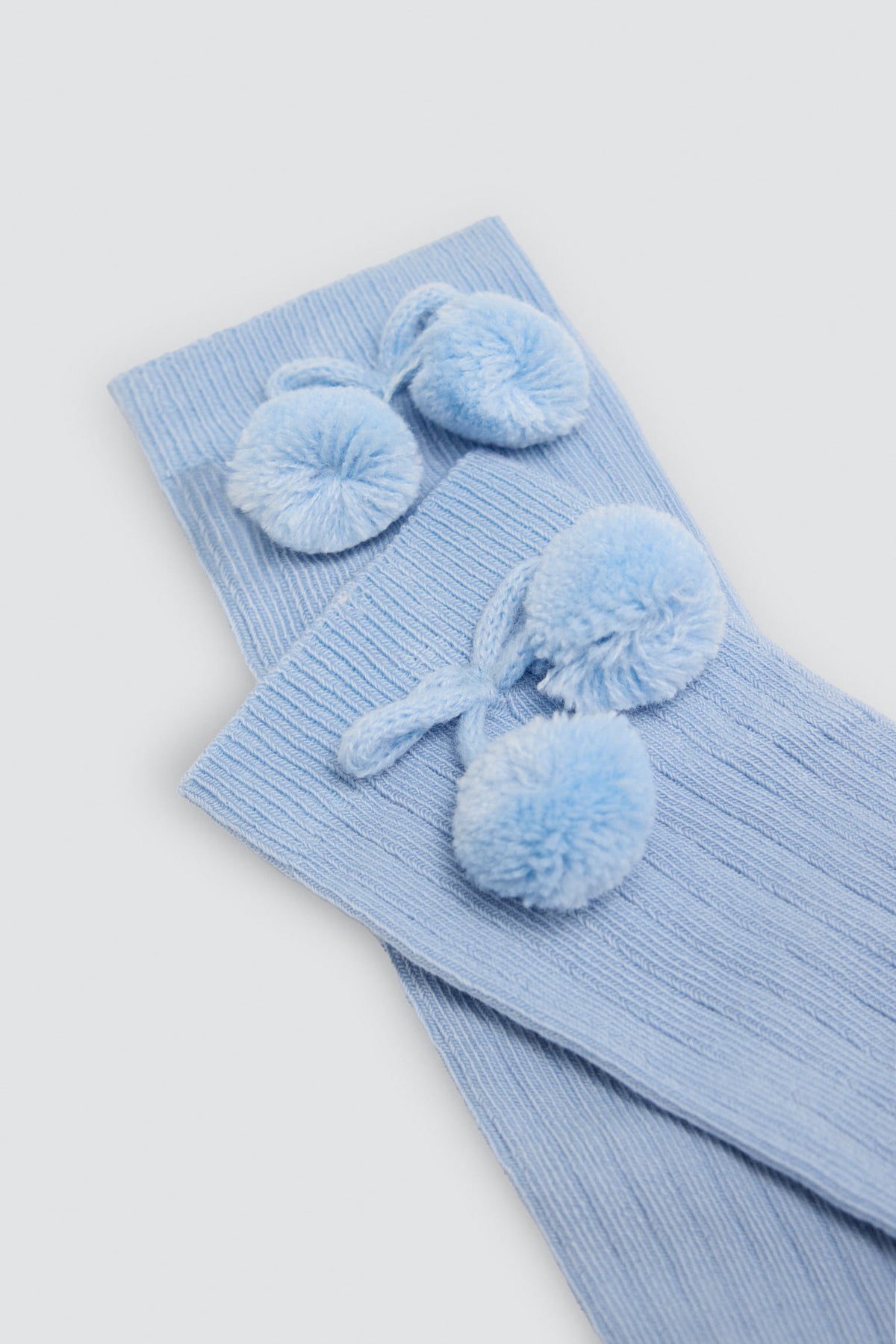 Meias altas infantis azuis com detalhes de pompons