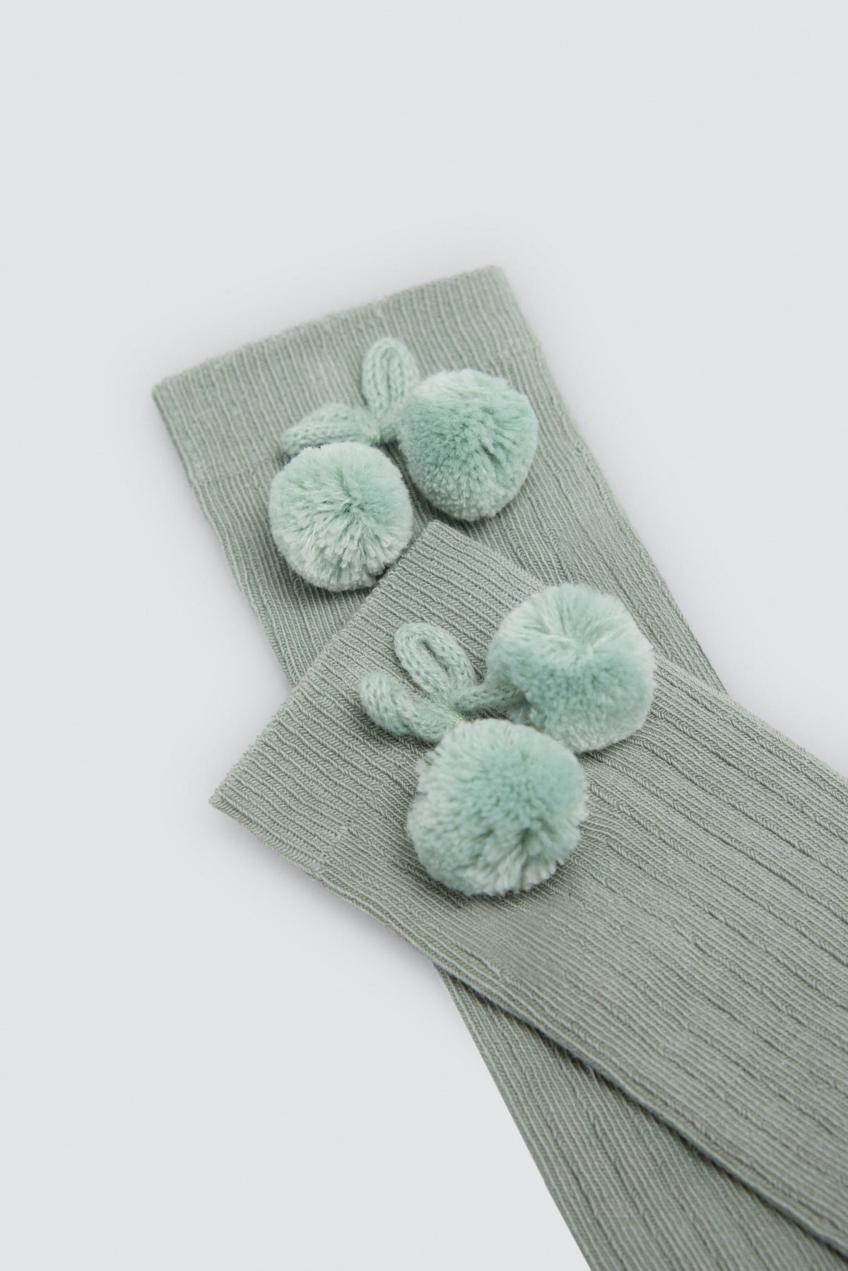Meias altas infantis verdes com detalhes de pompons