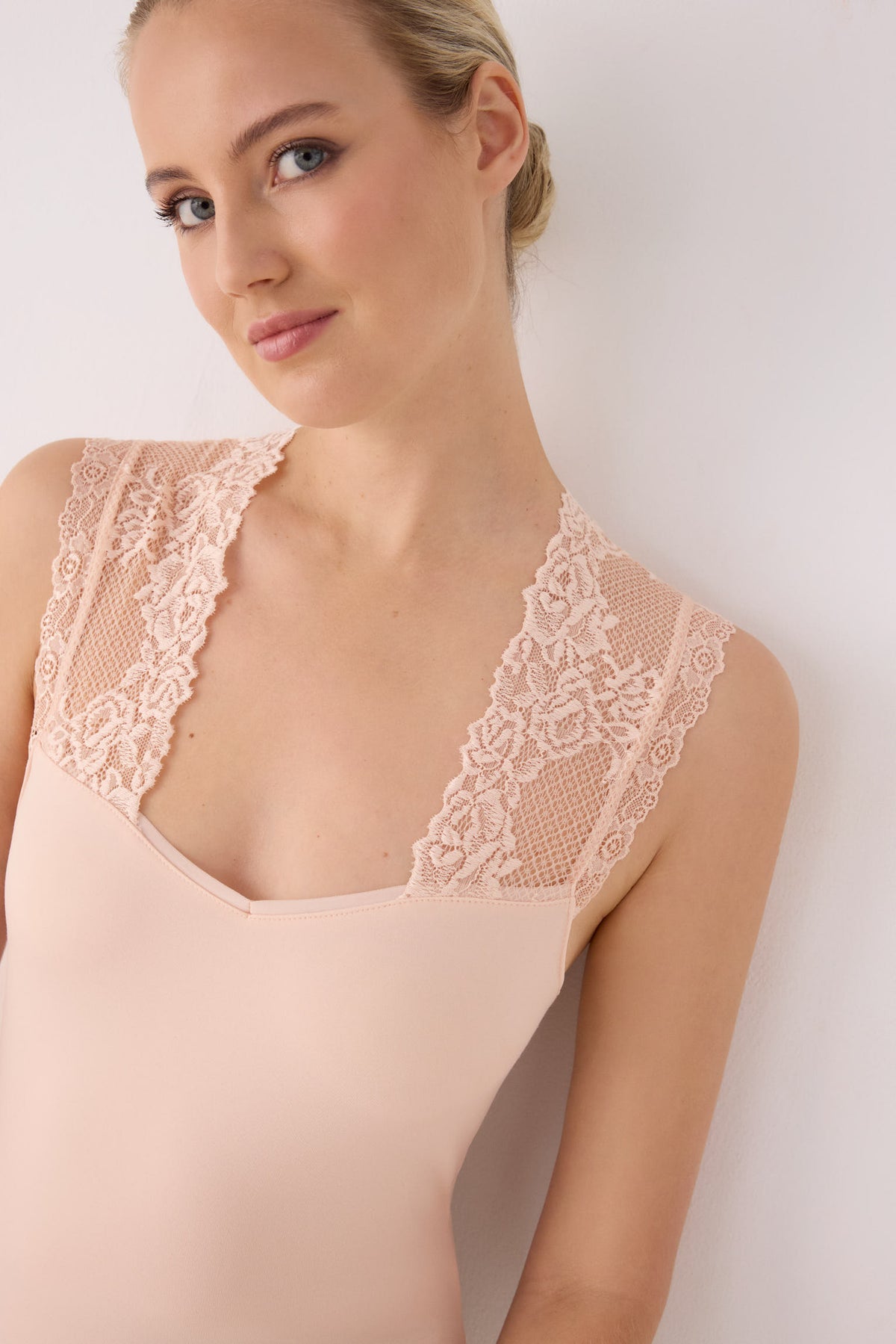 Camiseta térmica feminina sem mangas com detalhes em renda bege.