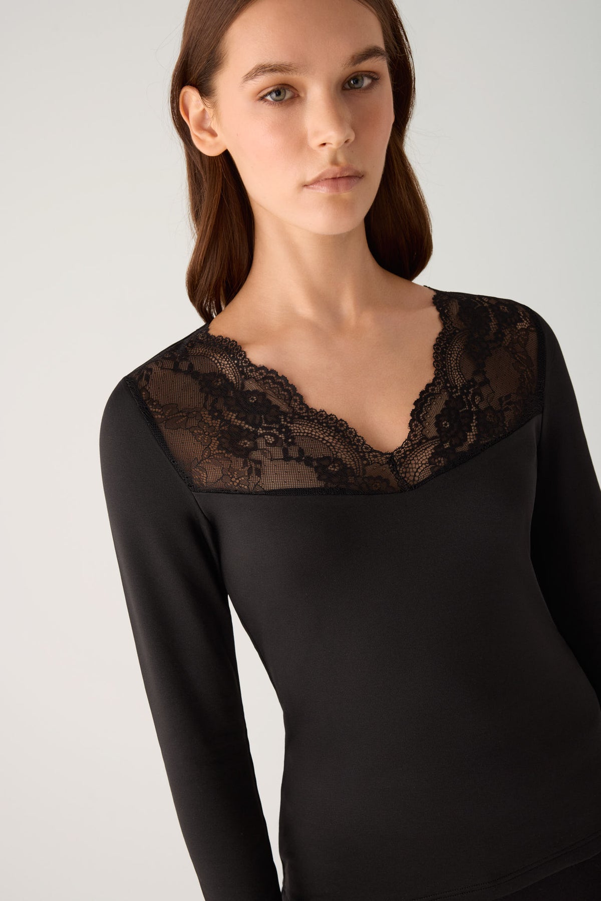 Camiseta térmica feminina de manga comprida com decote em V e detalhes em renda preta.