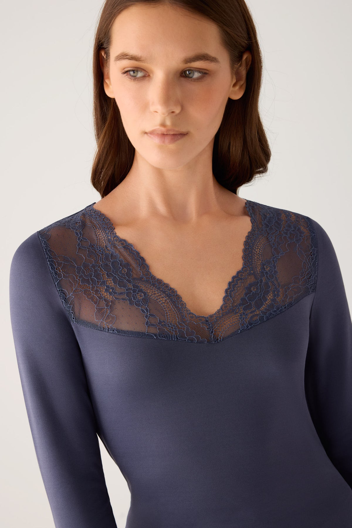 Camiseta térmica feminina de manga comprida com decote em V e detalhes em renda azul-marinho.