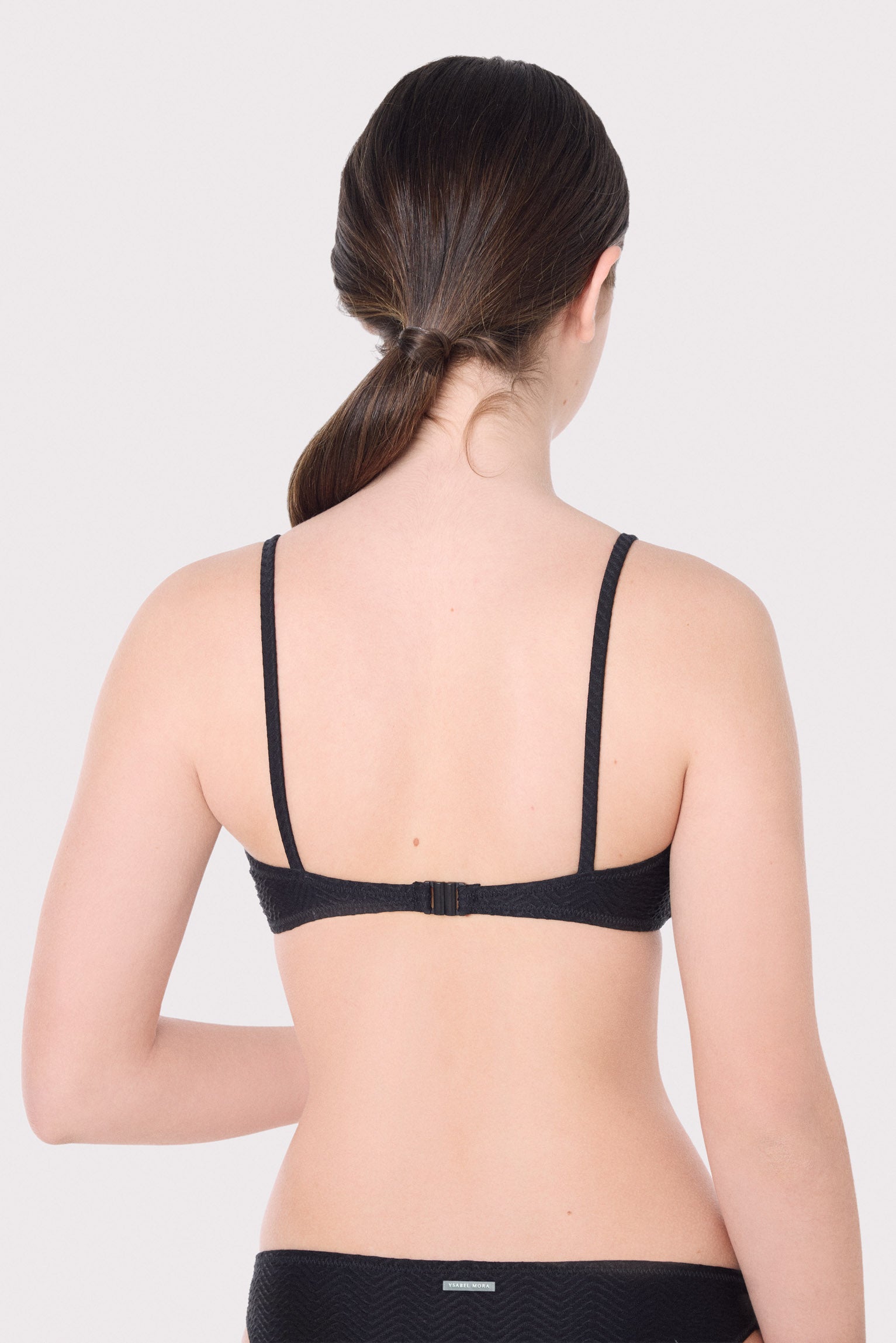 Top de biquíni juvenil texturizado com laço e bojo removível.