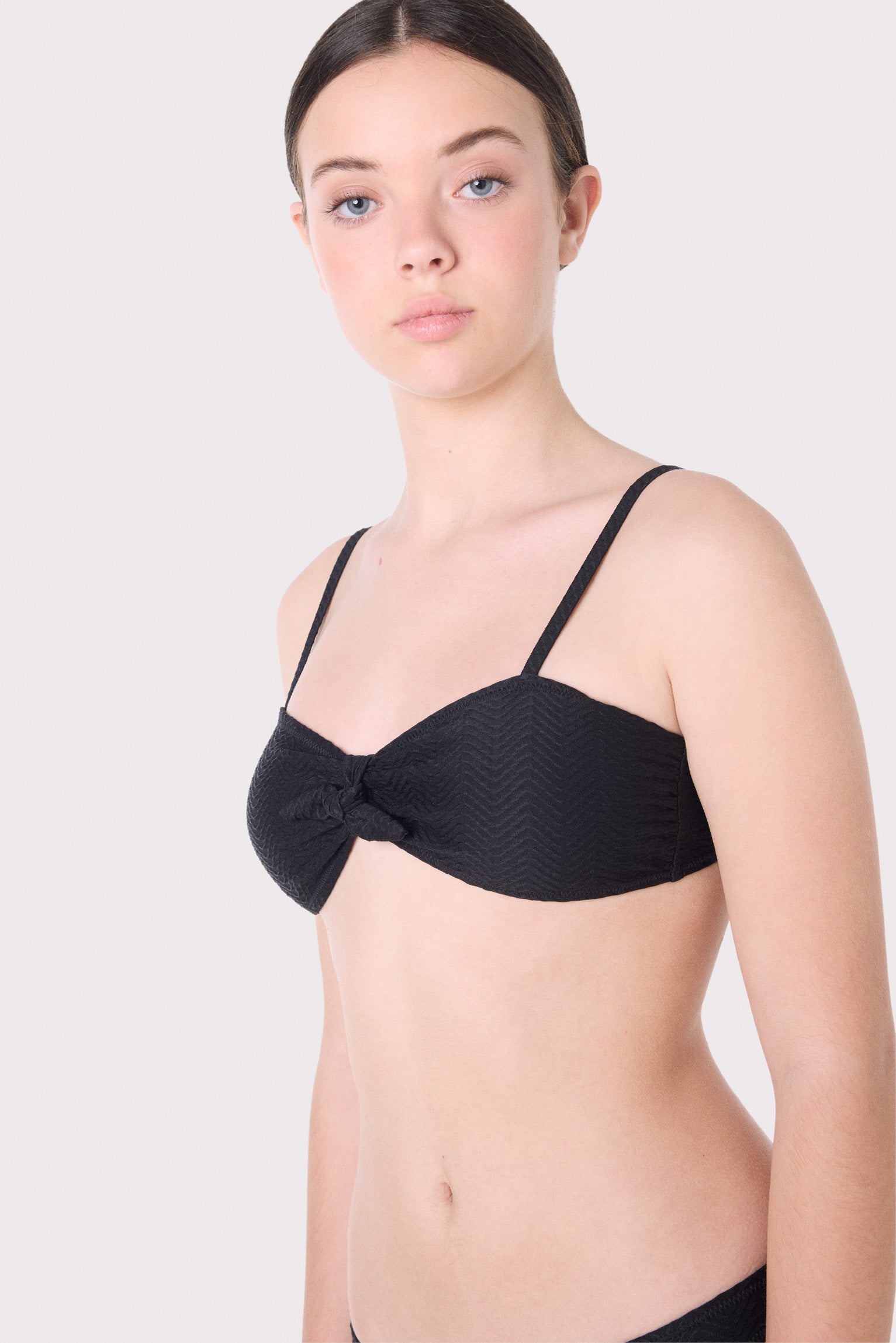 Top de biquíni juvenil texturizado com laço e bojo removível.