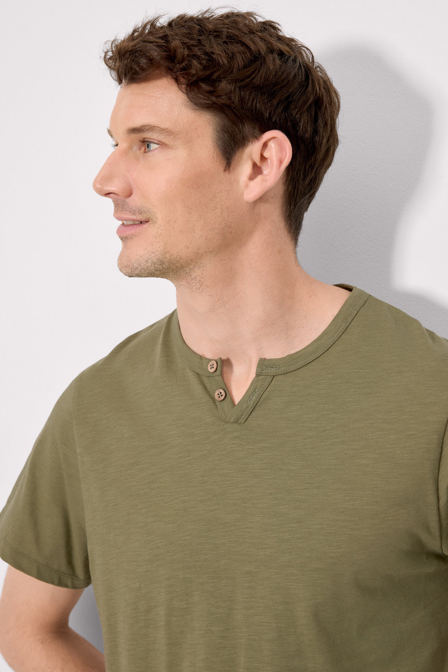 Camiseta básica de manga curta com gola henley na cor verde.