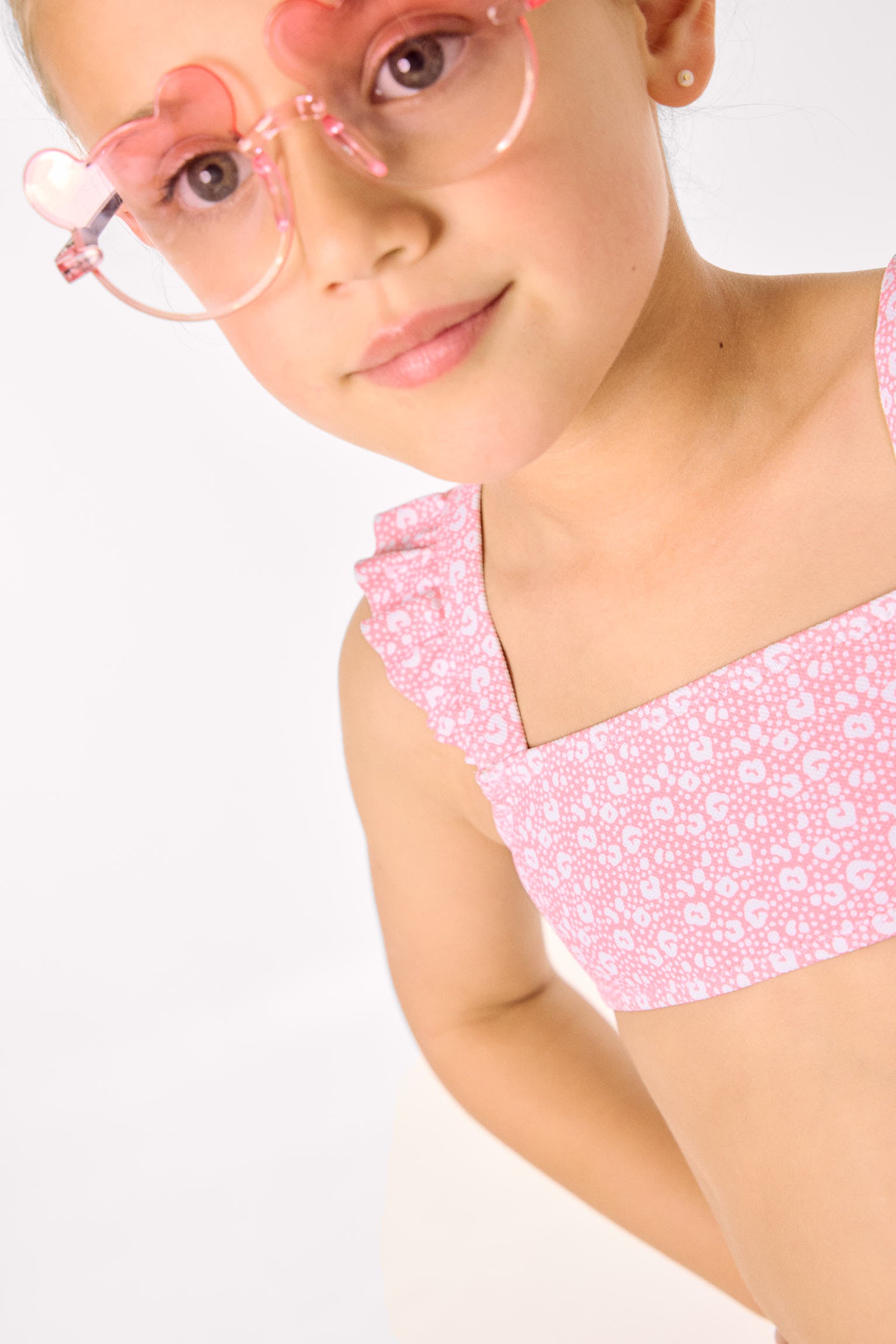 Biquíni infantil com detalhes em babados e estampa de leopardo rosa.