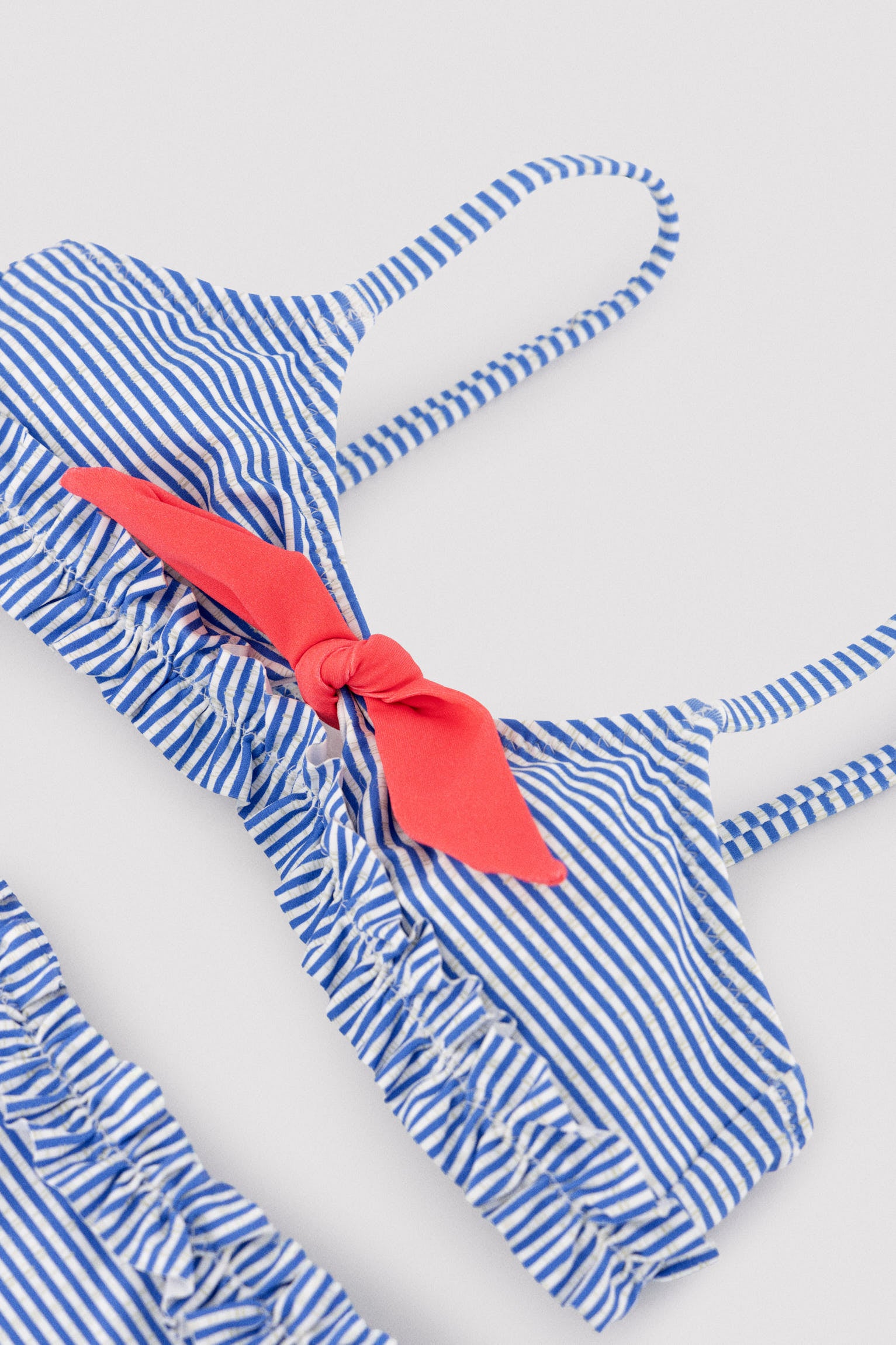 Biquíni infantil com detalhe de laço e franzido, estampa listrada