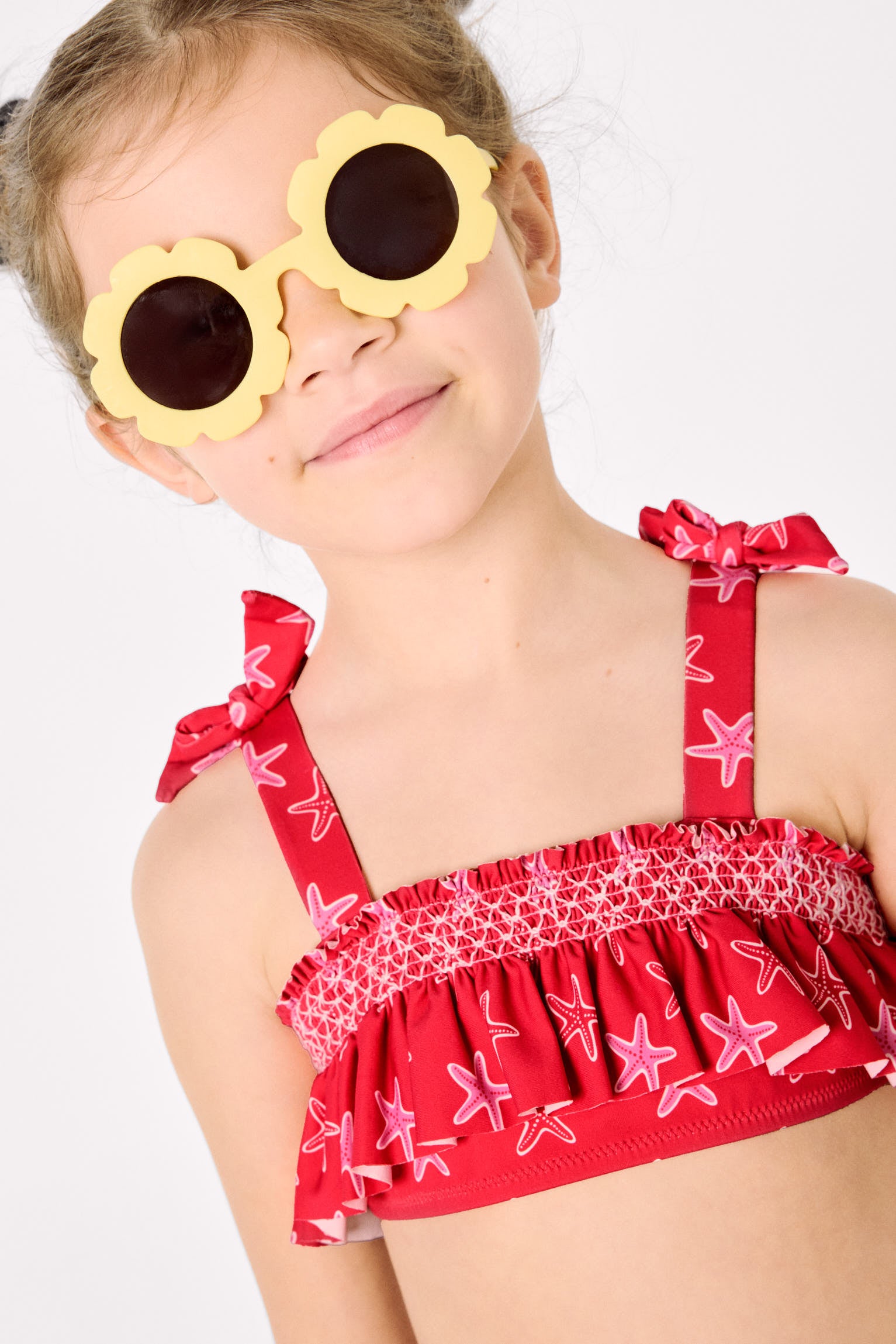 Biquíni infantil com detalhes em babados e estampa de favo de mel com estrelas-do-mar.