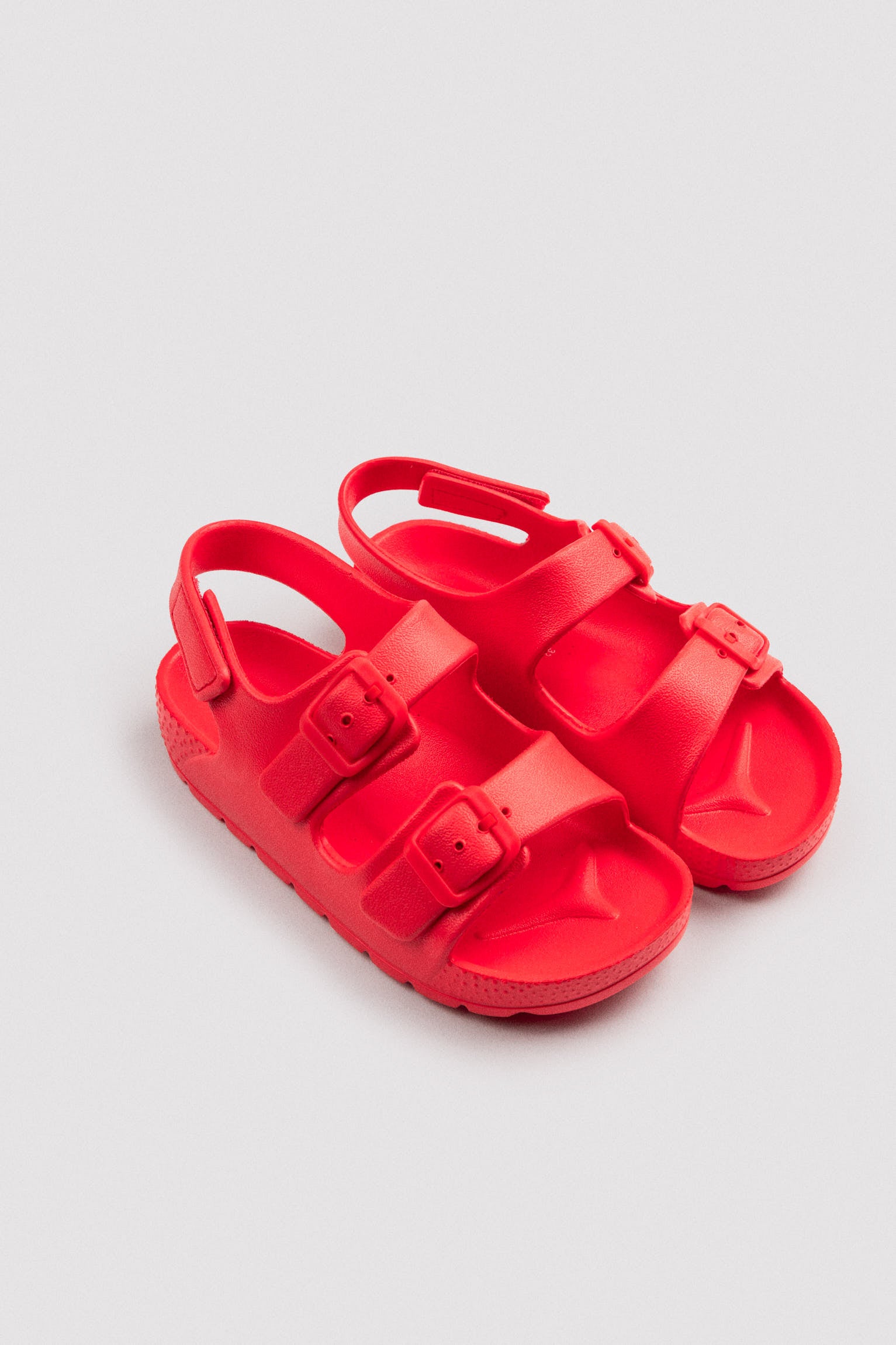 Chinelo infantil com fivelas ajustáveis ​​e velcro vermelho.
