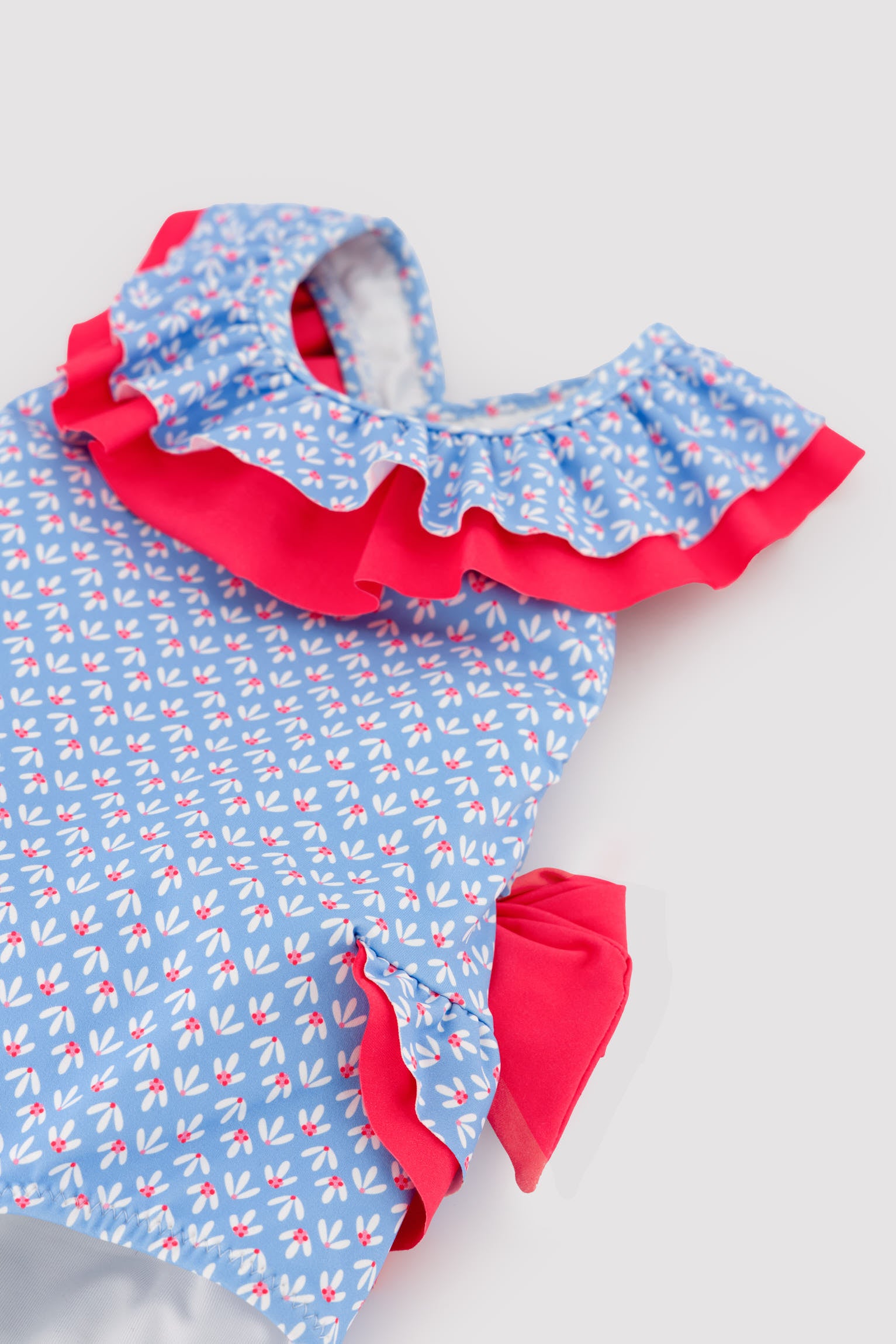 Maiô infantil para menina com detalhes de babados e laços, estampa floral.