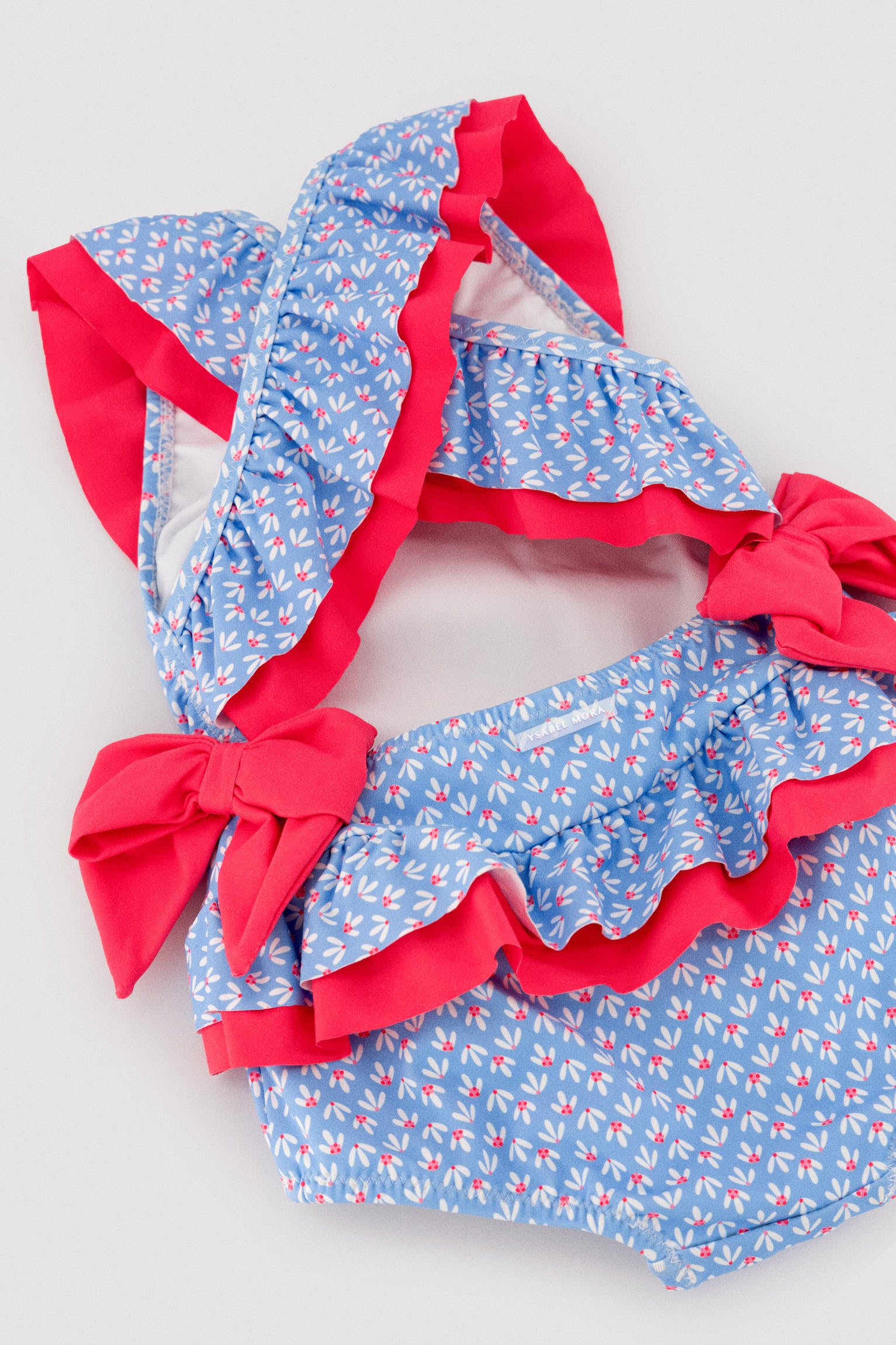 Maiô infantil para menina com detalhes de babados e laços, estampa floral.